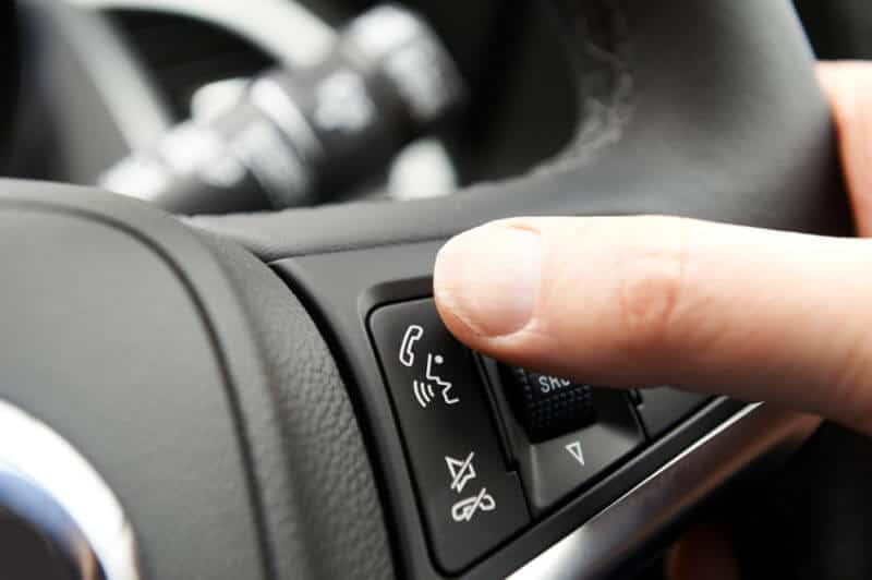 Close Up Of Hand Pressing Car Bluetooth Control On Steering Whee