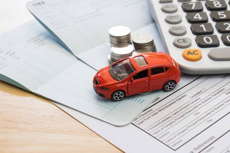 Cars with Low Insurance Rates toy car on top of papers and coins to symbolize car insurance