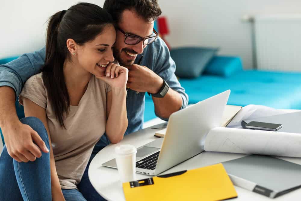 glückliches Paar im Laptop, das Autoversicherung online kauft