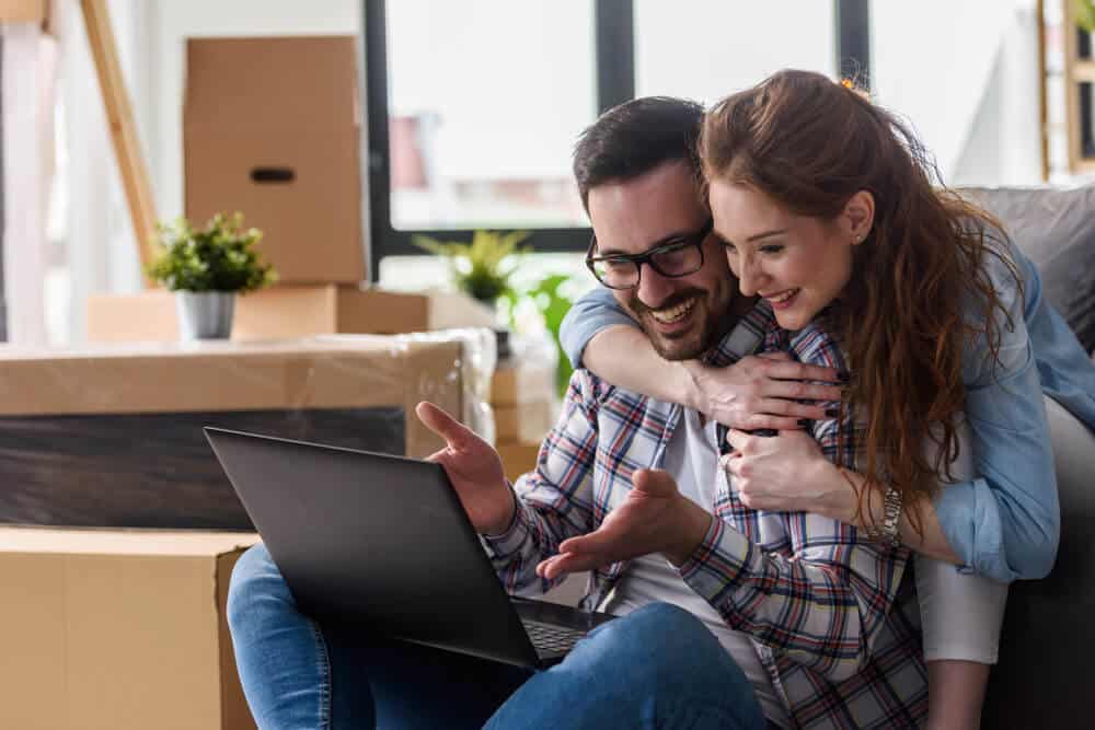 couple in new home looking at laptop