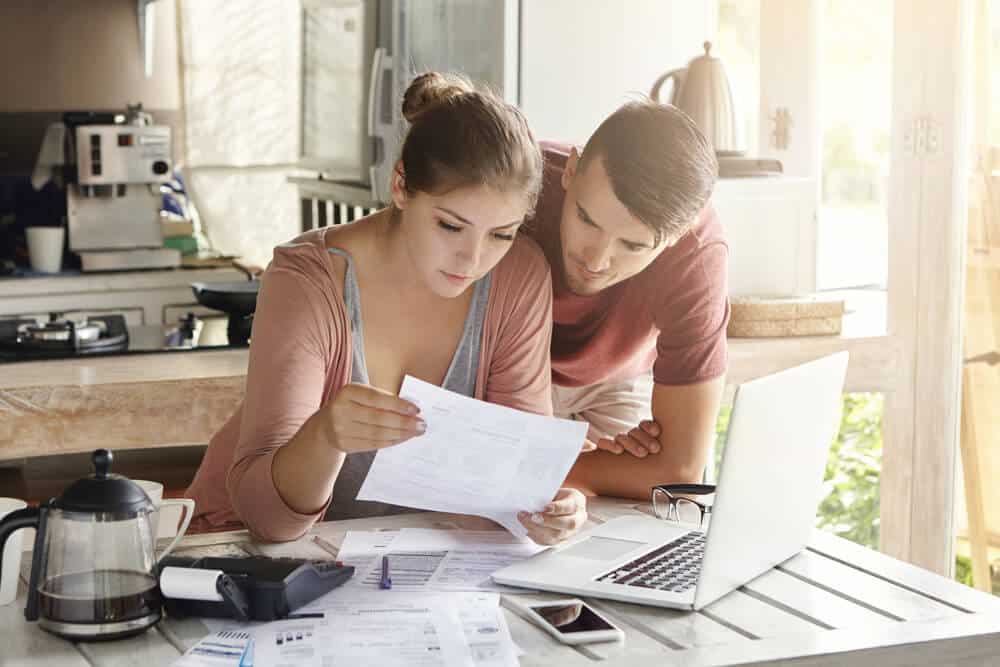 couple in kitchen looking at car insurance bills in their kitchen