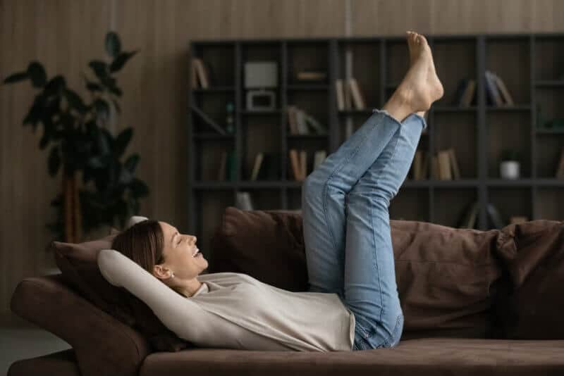 relaxed young woman in her couch with feet up