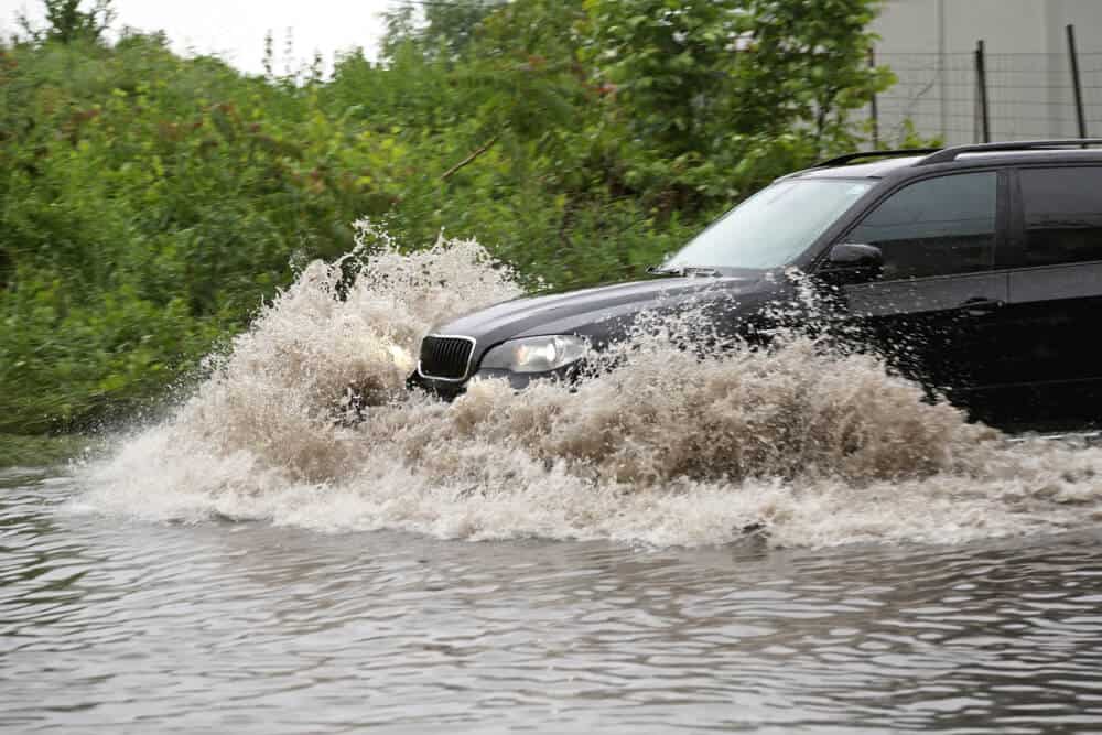 suv driving through flooded road