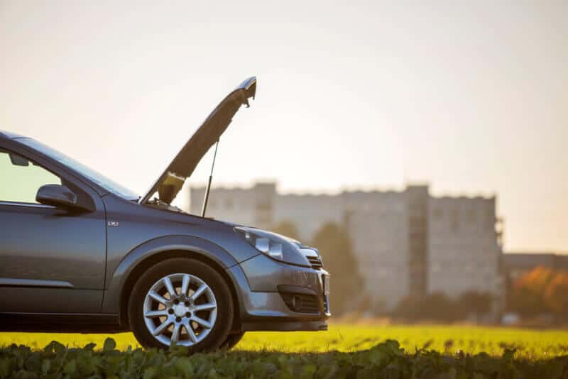 Side,View,Detail,Of,Car,With,Open,Hood,On,Empty car pulled over on side of road with hood up