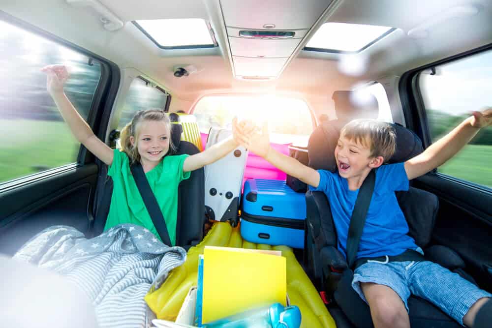 two young children in back of car on road trip