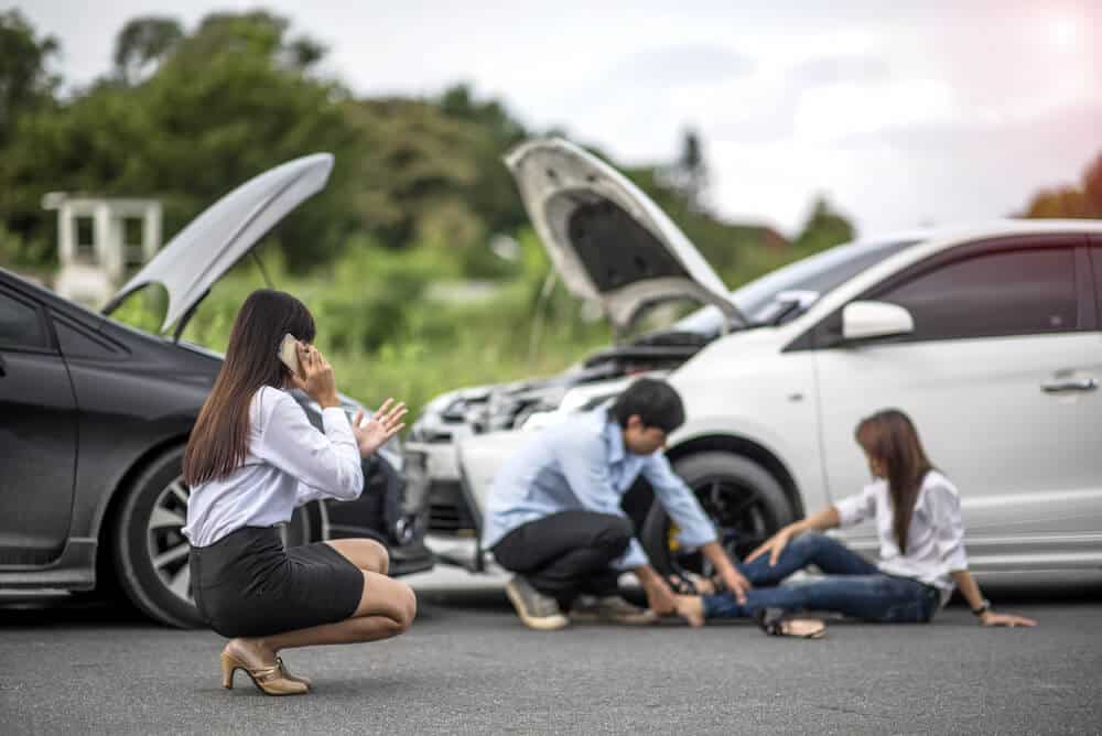 woman calling for help after car accident with injured people