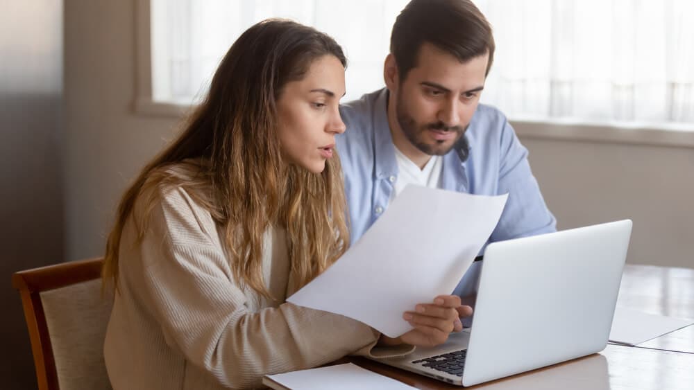 couple reviewing auto insurance companies on laptop