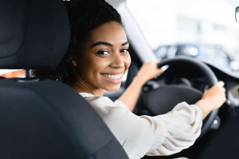 Afro,Woman,Driver,Buying,New,Car,Doing,Test,Drive,Choosing african american woman smiling behind wheel of car
