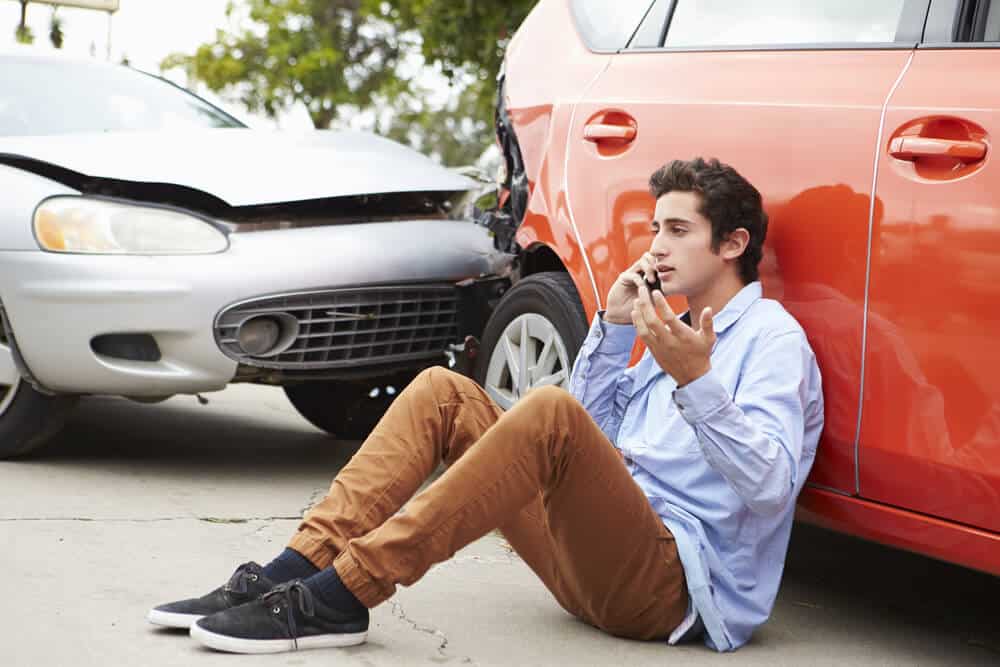 teen driver making phone call by car accident