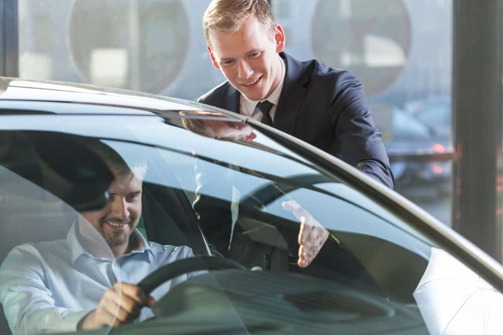 man taking a used car for a test drive with car salesman
