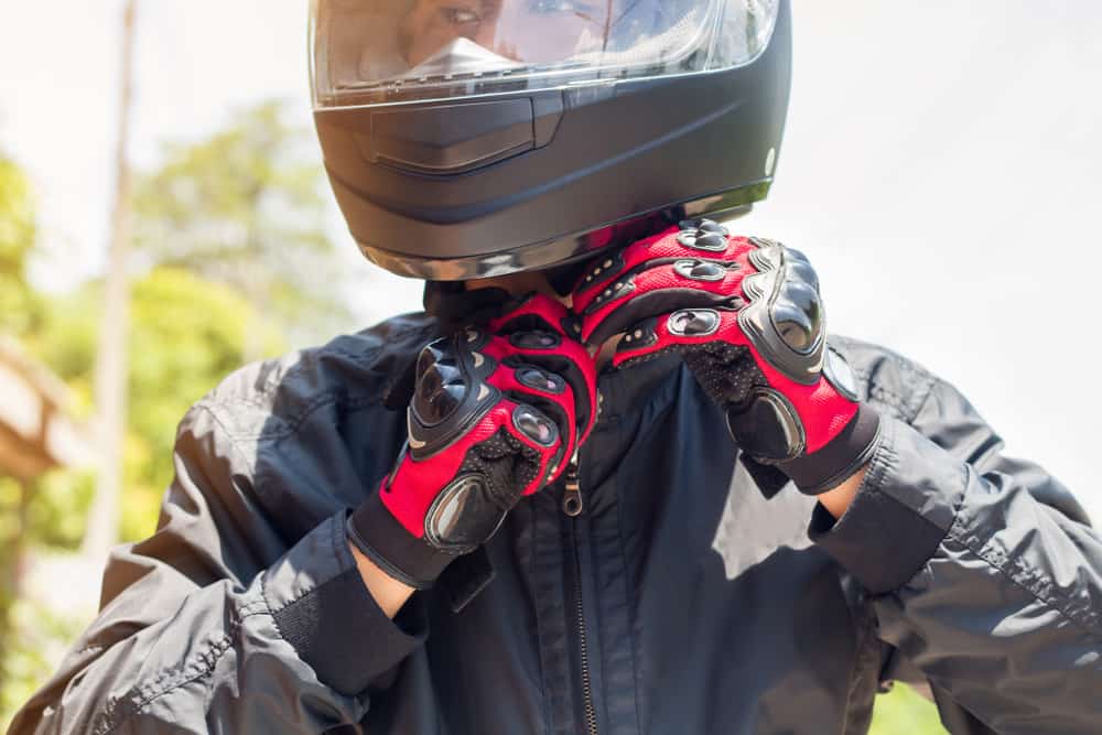 man on motorcycle putting on helmet