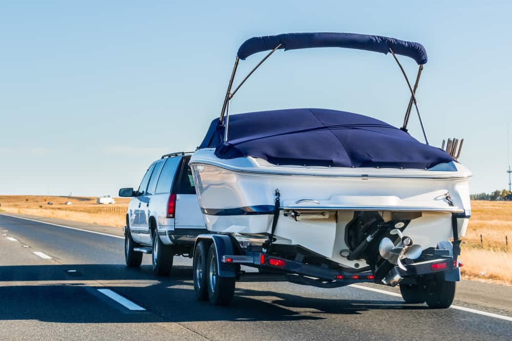 SUV pulling boat trailer on road