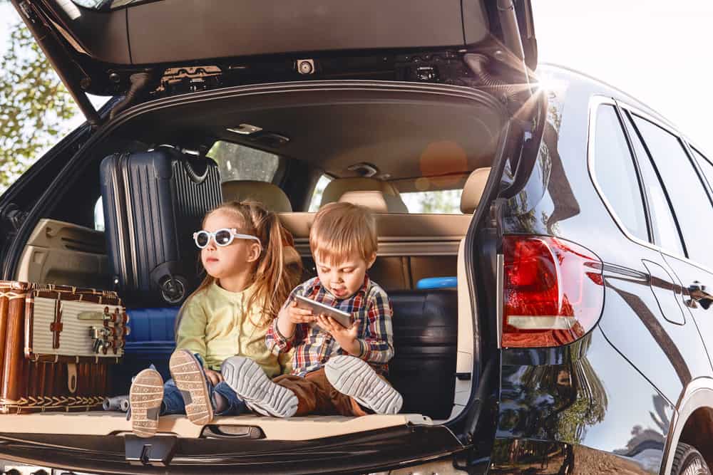 kids sitting in back of car before road trip